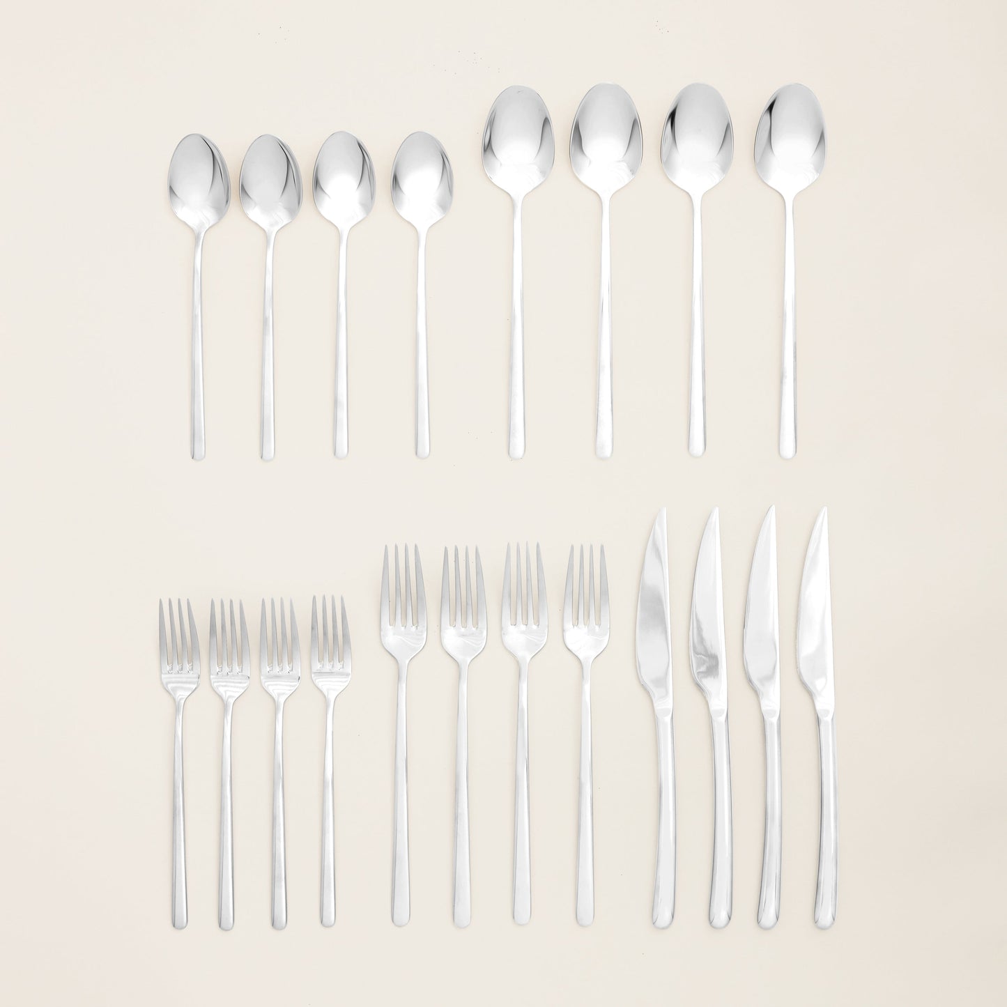 Single Emilia mirror polish teaspoon on plain studio background
