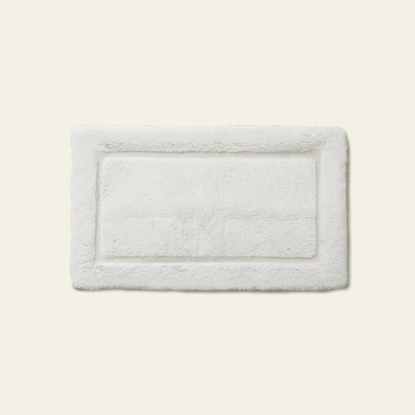 Bath mat folded in half showing thickness and dense pile material