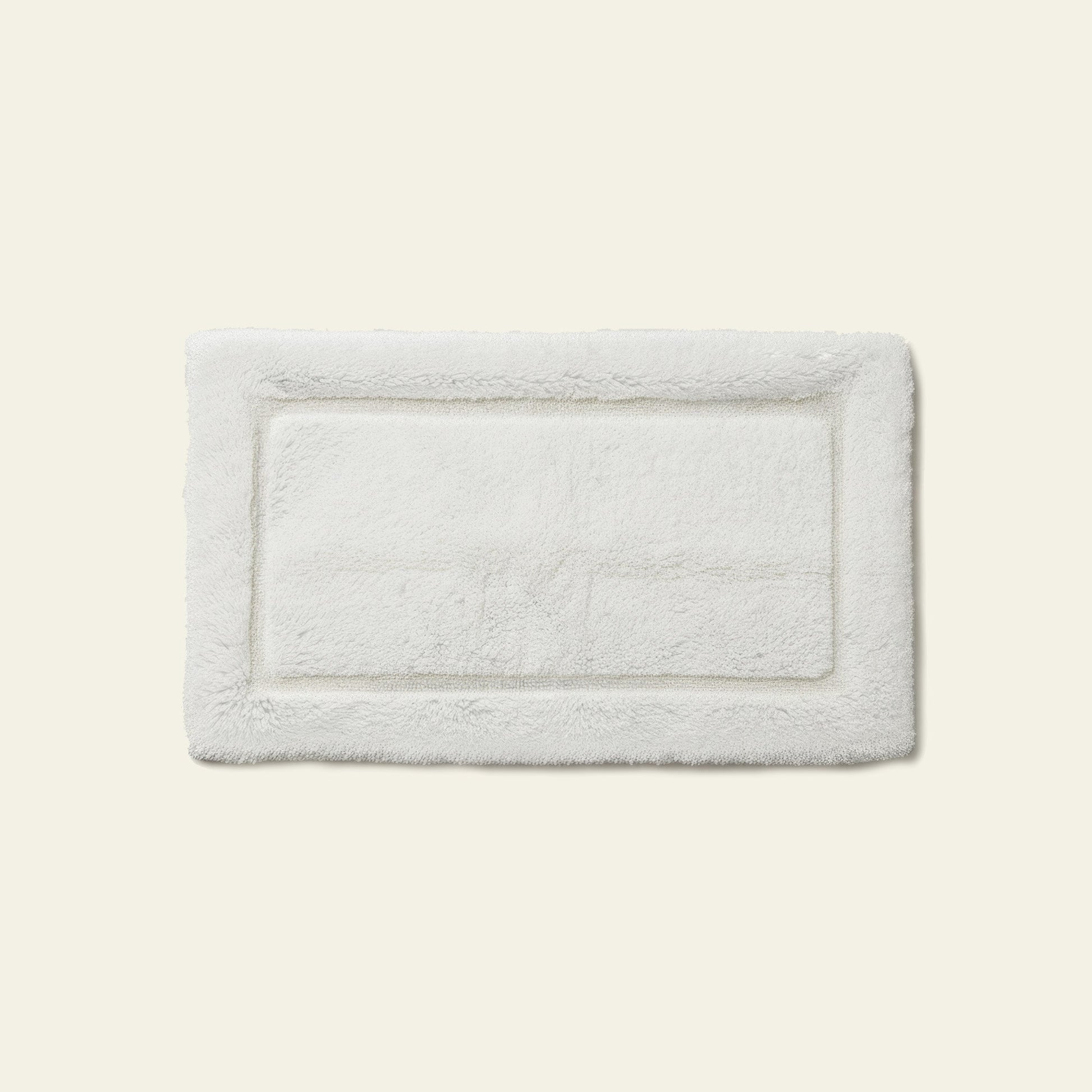 Bath mat folded in half showing thickness and dense pile material