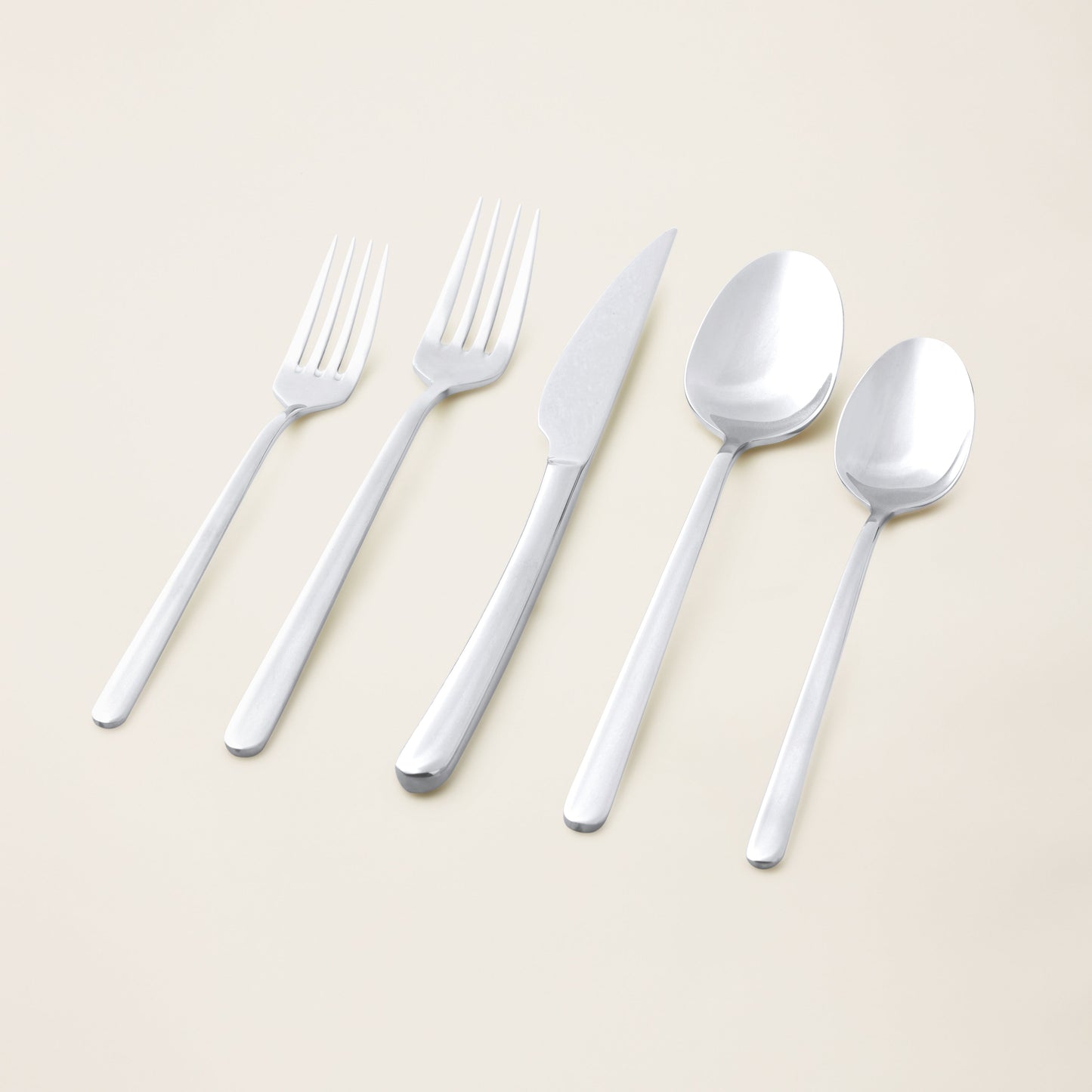 Single Emilia mirror polish soup spoon on plain studio background