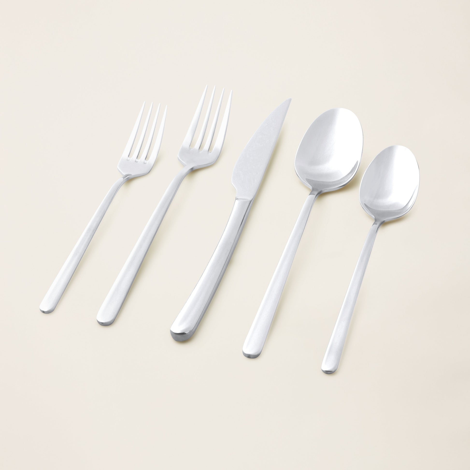 Single Emilia mirror polish soup spoon on plain studio background
