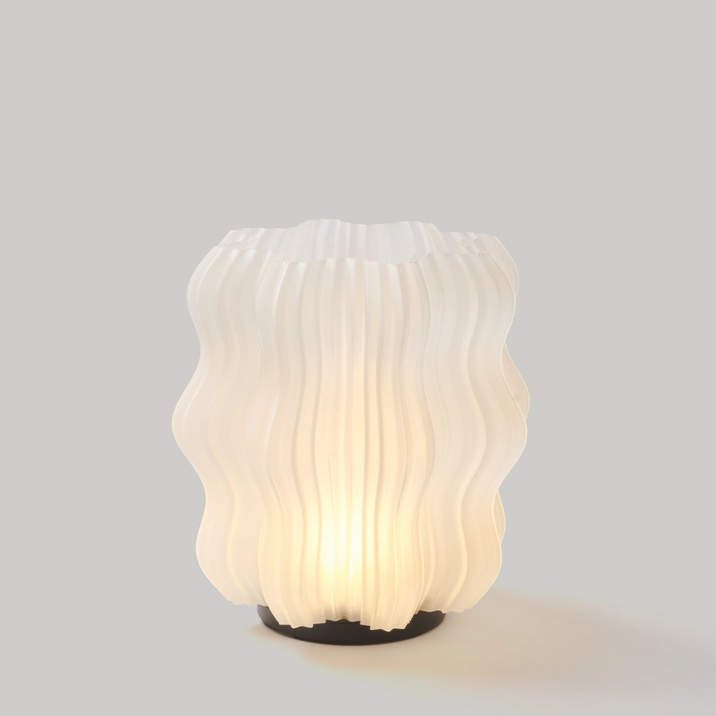 Mini Wavy Lamp styled on bookshelf next to small decorative objects