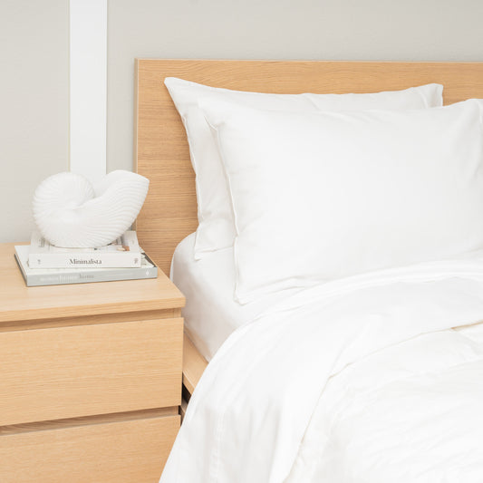 Organic cotton sateen bed sheet set in white styled on a neatly made bed