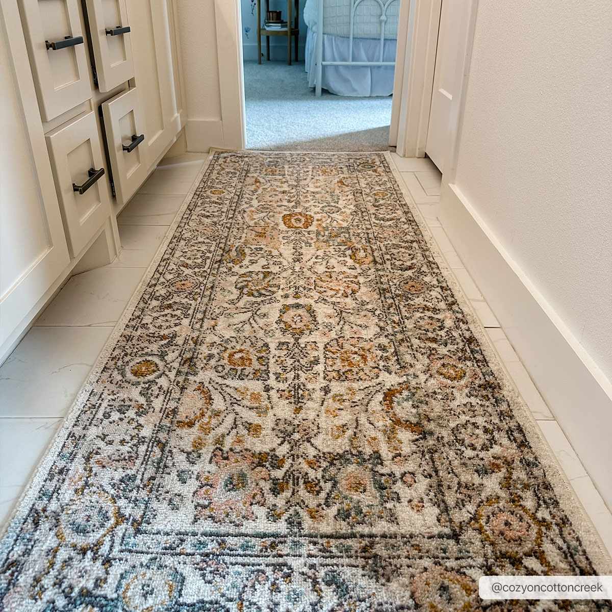 Herstmonceux rug in bedroom layered under upholstered bed frame