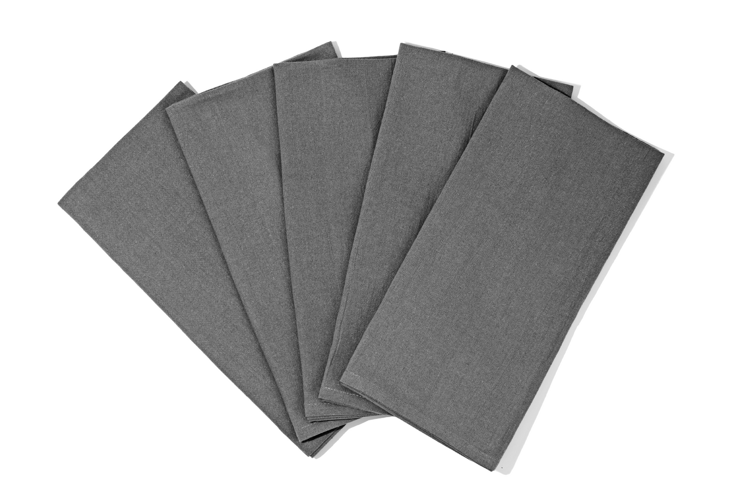 Flour sack towels arranged fan-style on a marble countertop near a window