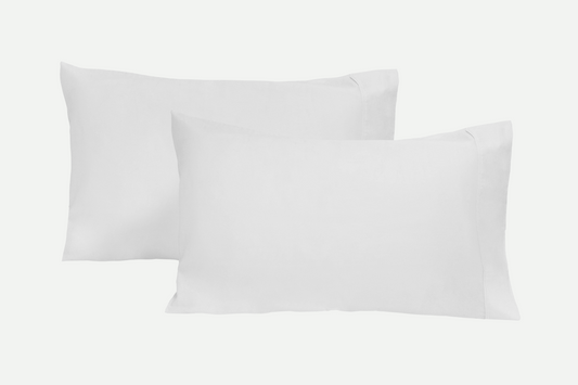 Pair of organic sateen pillowcases in white shown stacked with crisp folded edges