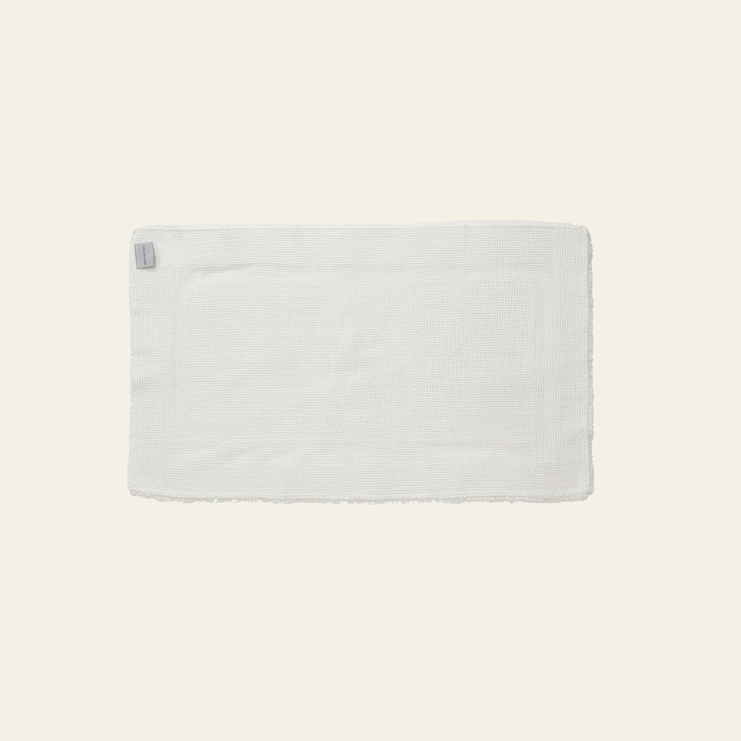 Bath mat in stone gray color photographed flat on plain background