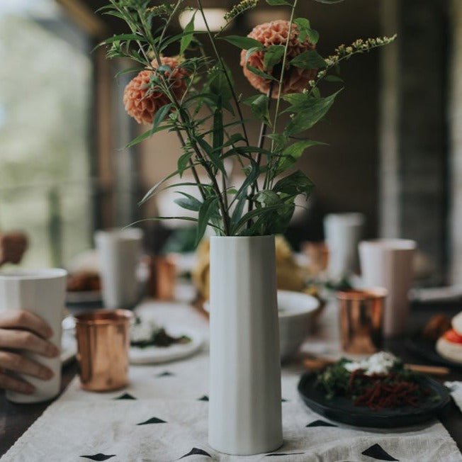 Bloom Vase with single eucalyptus stem photographed on warm linen surface