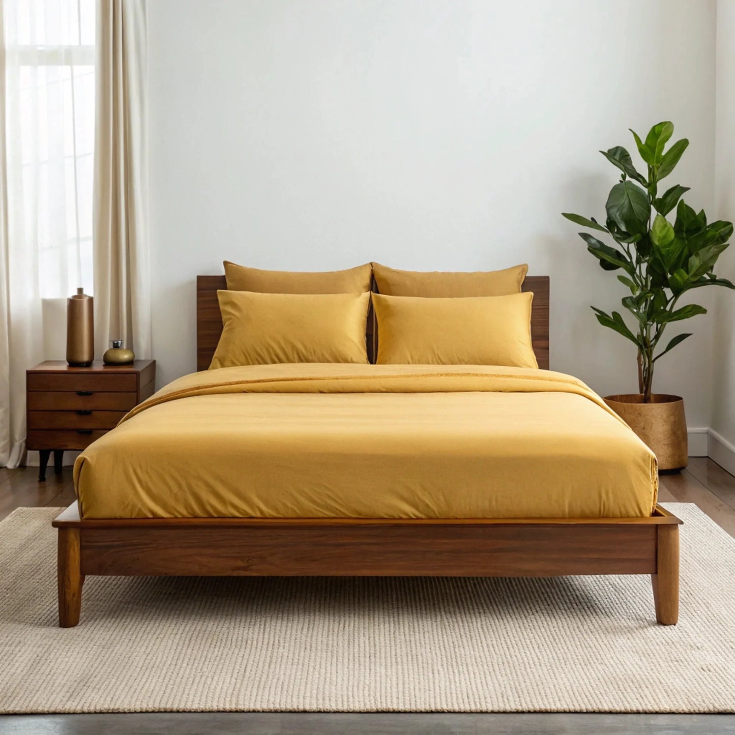 Bamboo sheet set in soft blush pink stacked beside a small flower vase