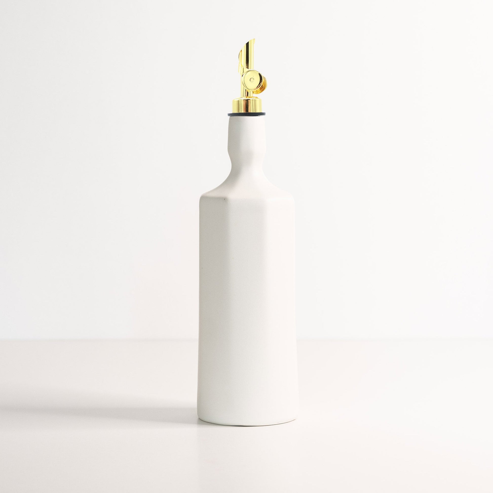 Side profile of Elixir dispenser showing curved porcelain bottle silhouette