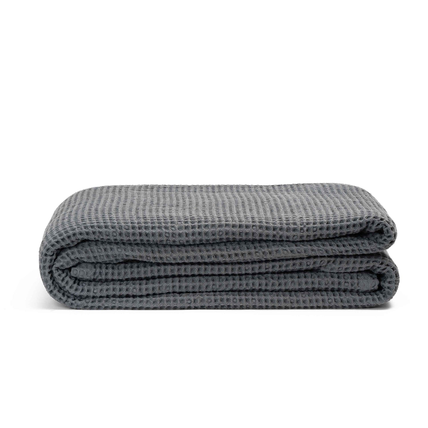 Waffle weave throw rolled up showing fringed tassel detail on each end