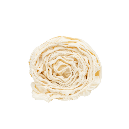 Organic sateen fitted sheet in white stretched neatly over a queen mattress